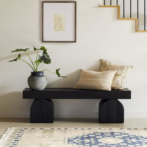 Modern black bench with bold geometric design used as a hallway accent