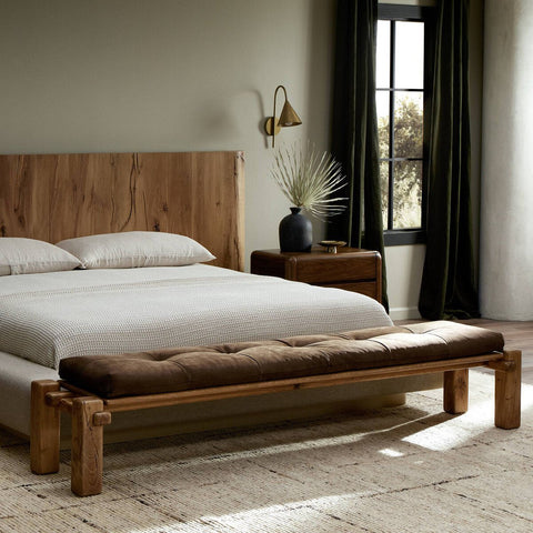 wooden bench with brown tufted cushion placed at the end of a bed