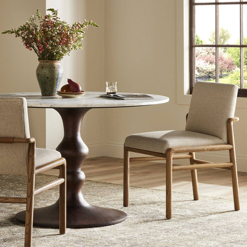 Small round bistro dining table with light modern wooden chairs with cream upholstrey